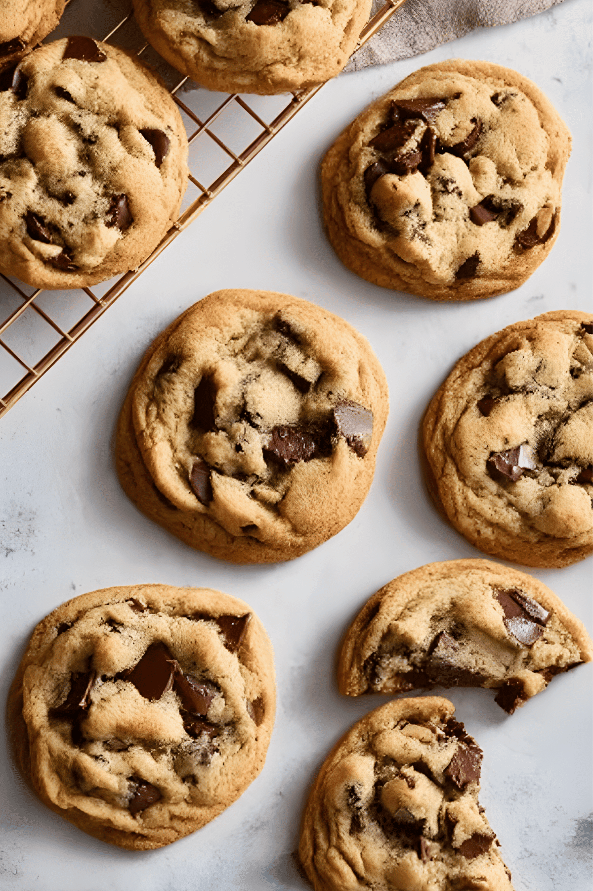 Chocolate chunk cookies on gray surface and rack